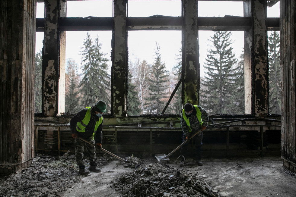 Dos trabajadores eliminan los escombros en el Ayuntamiento de Almaty, Kazajistán